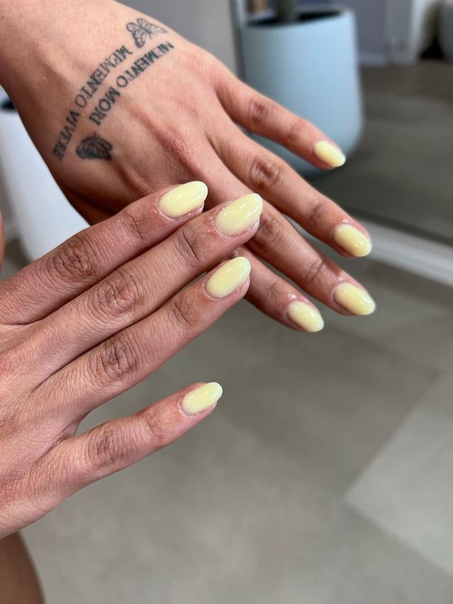 Almond-shaped nails in a soft butter yellow