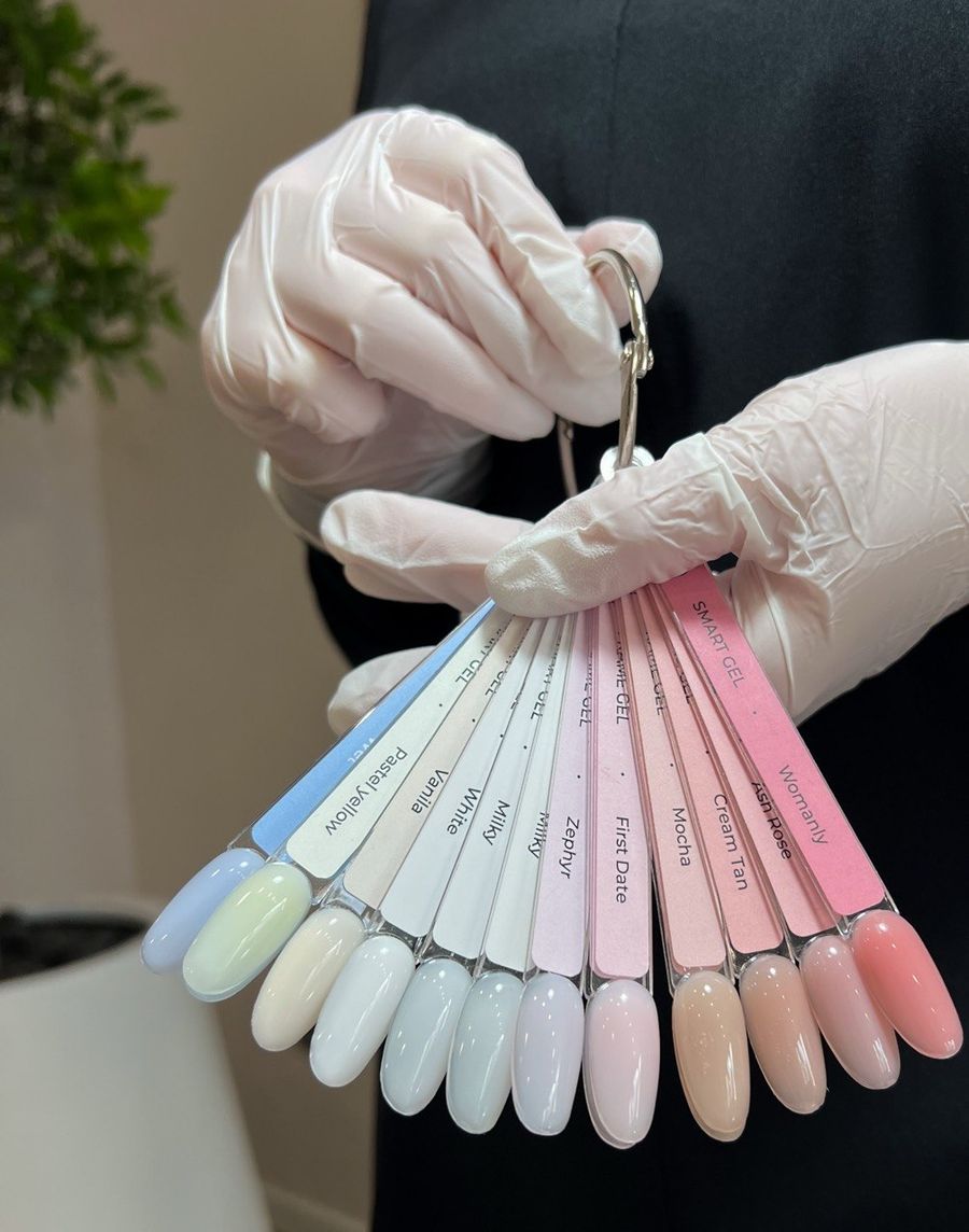 Farbfächer mit ausgehärteten Gel-Lack-Tönen, gehalten mit Handschuhen
