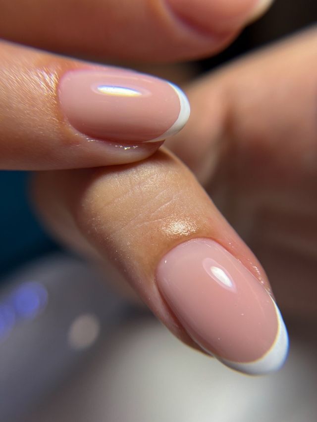 Close-up: nude pink nails with a narrow white French tip