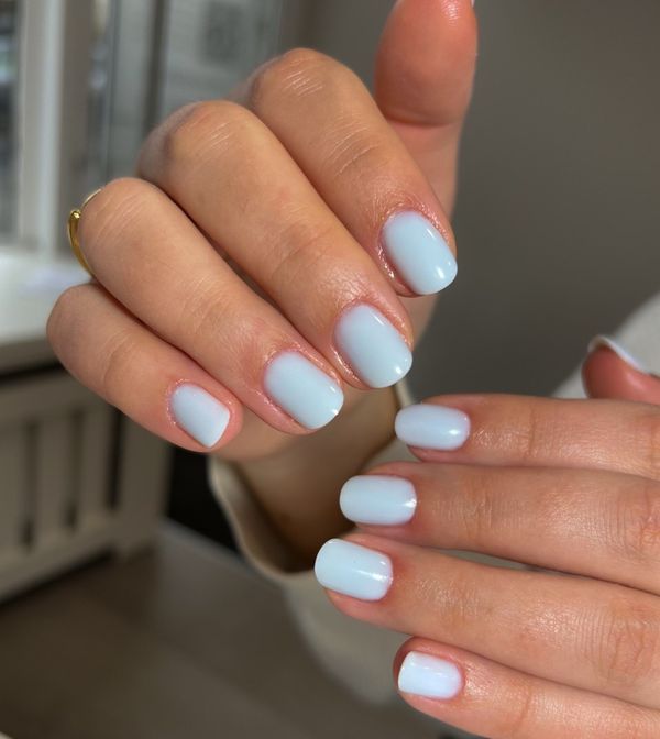Short square nails in a milky pale blue