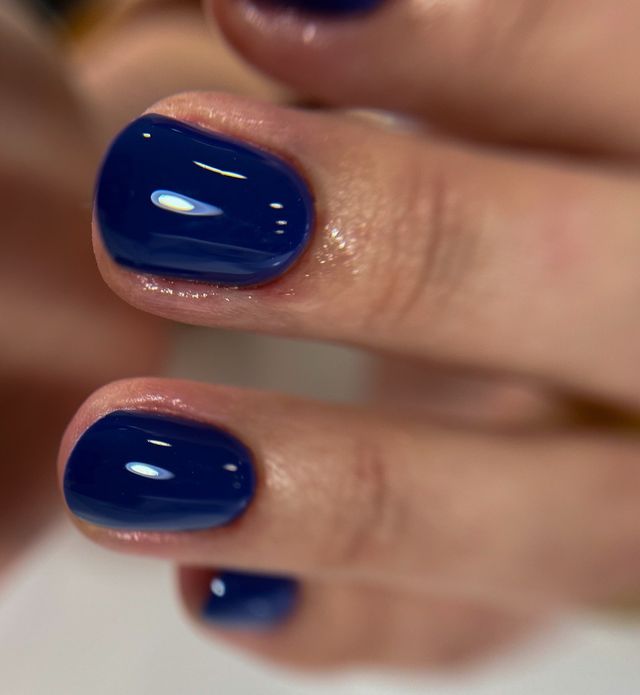 Short oval nails in a deep navy blue